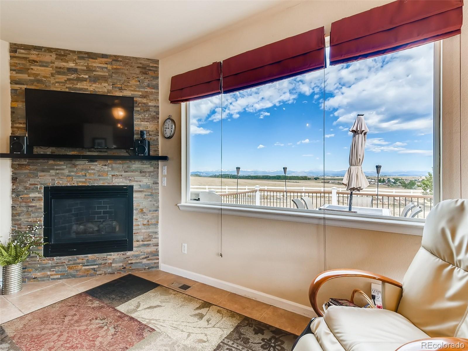 8209 County Road 2 Brighton, CO 80603 - Photo 15 of 40 a living room with furniture a flat screen tv and a fireplace