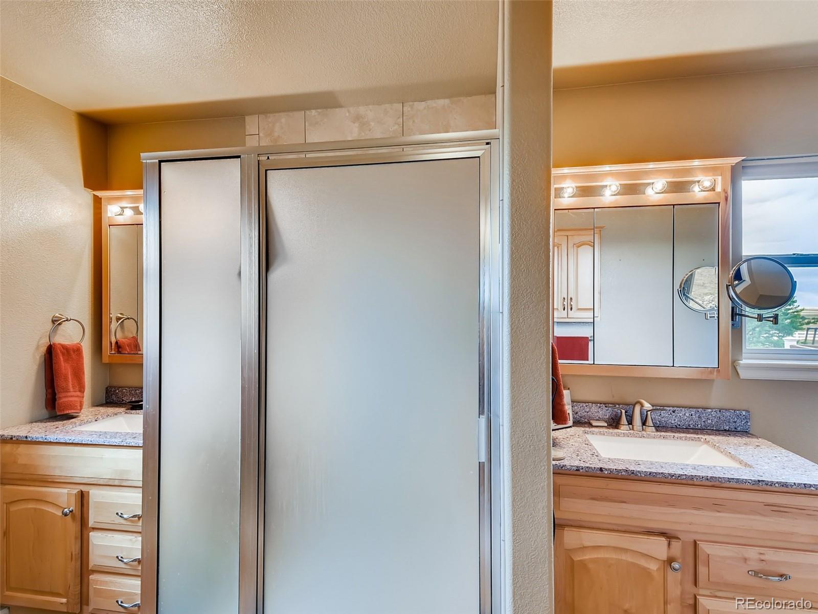 8209 County Road 2 Brighton, CO 80603 - Photo 25 of 40 a bathroom with a granite countertop sink a mirror and a shower