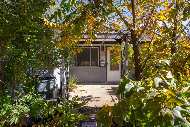 a front view of a house with a tree