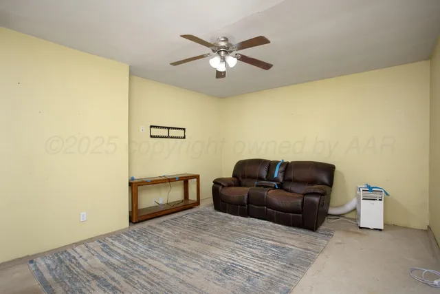 a living room with couch and a ceiling fan