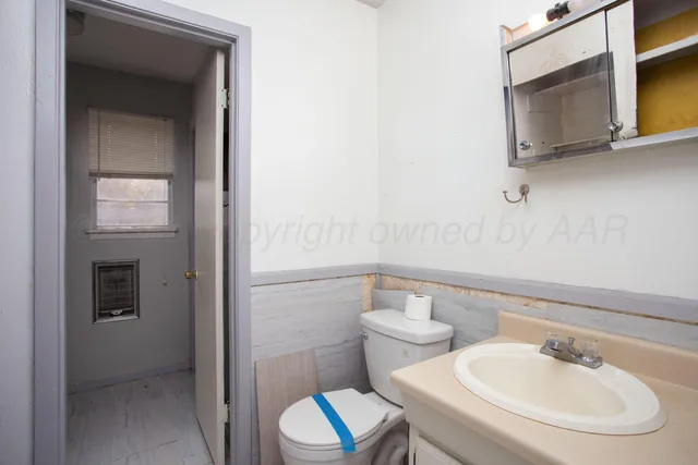 a bathroom with a toilet a sink and mirror