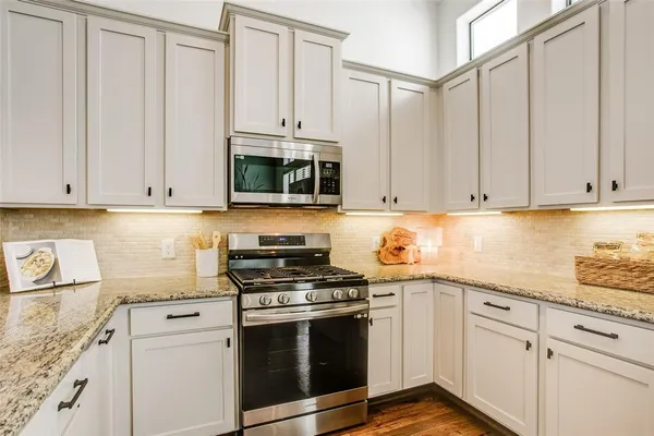 a kitchen with stainless steel appliances granite countertop a sink and a stove