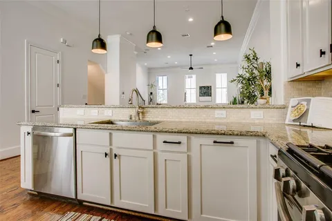 a kitchen with granite countertop white cabinets and stainless steel appliances