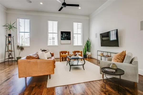 a living room with furniture wooden floor and a flat screen tv