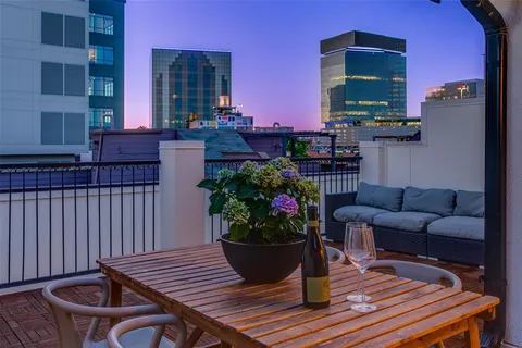 a view of a deck with table and chairs potted plants