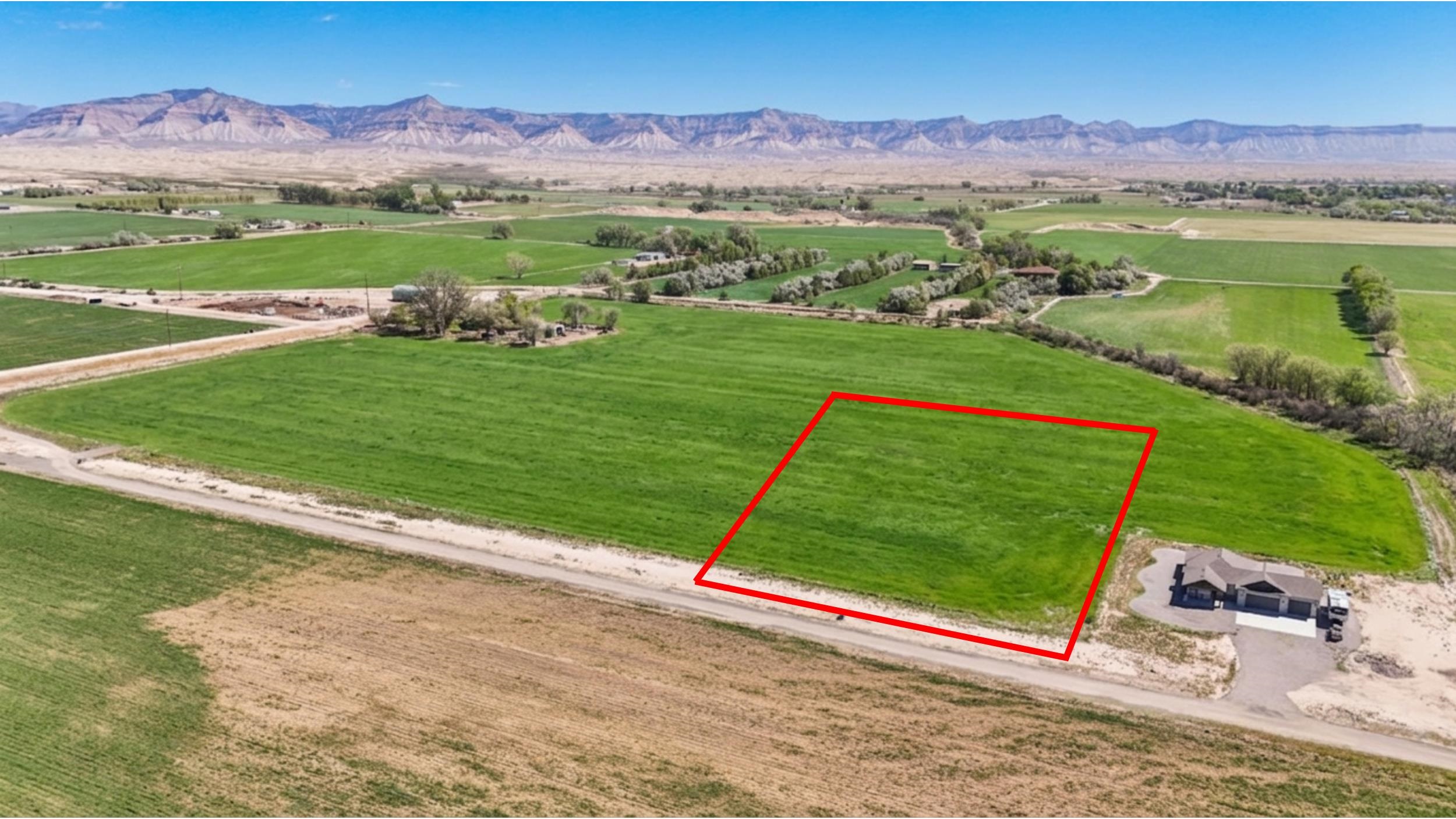 1242 21 Road Grand Junction, CO 81505 - Photo 2 of 7 an aerial view of a golf course with a mountain