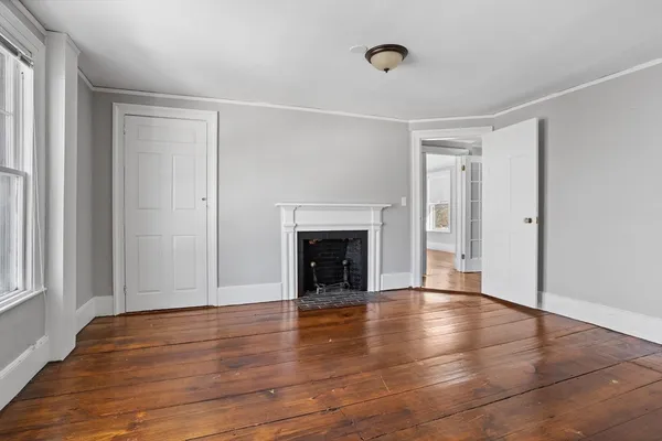 a view of a livingroom with wooden floor and a fireplace