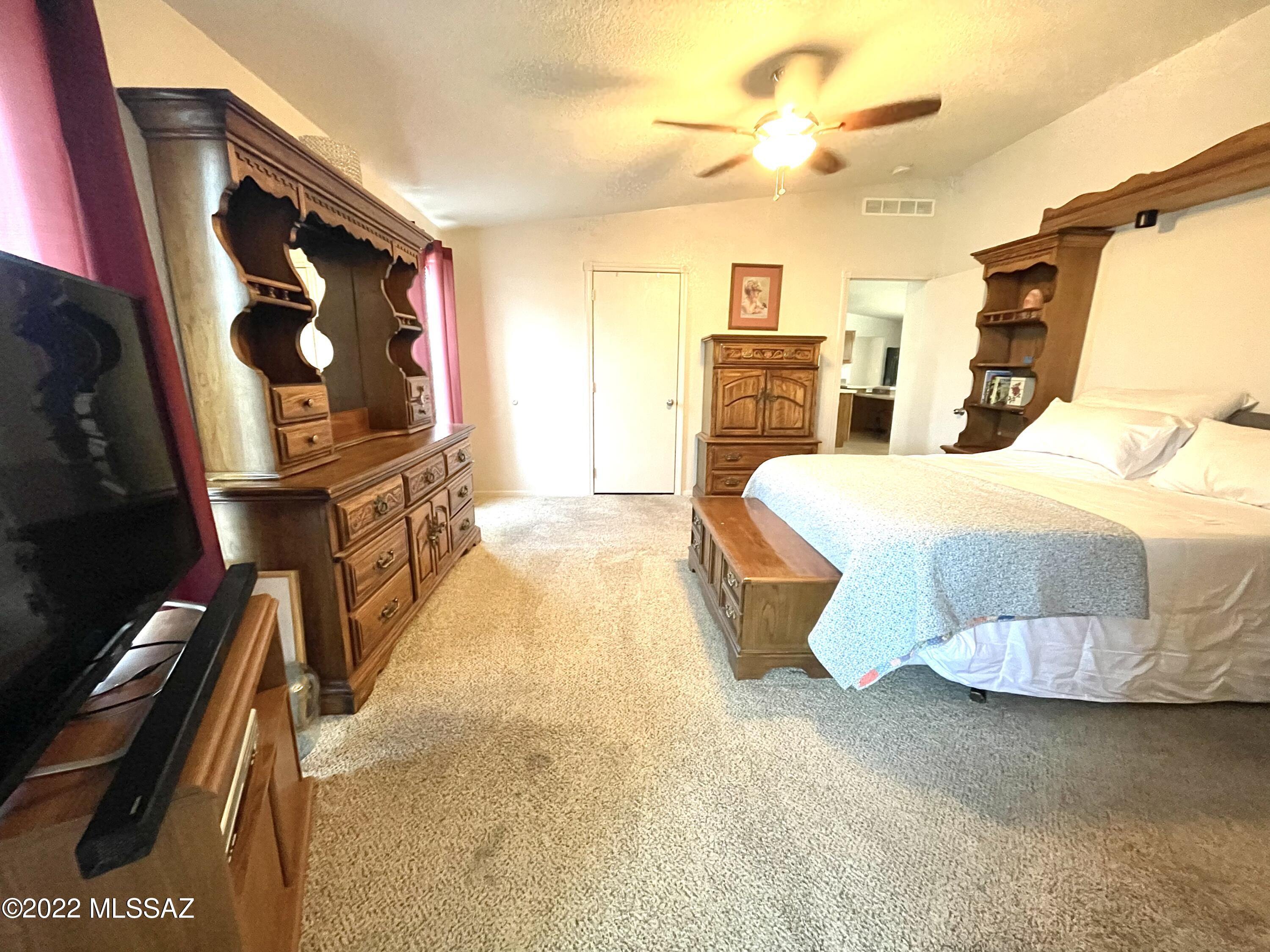 13643 East Bright Sky Loop Vail, AZ 85641 - Photo 18 of 22 a bedroom with a bed and a chandelier