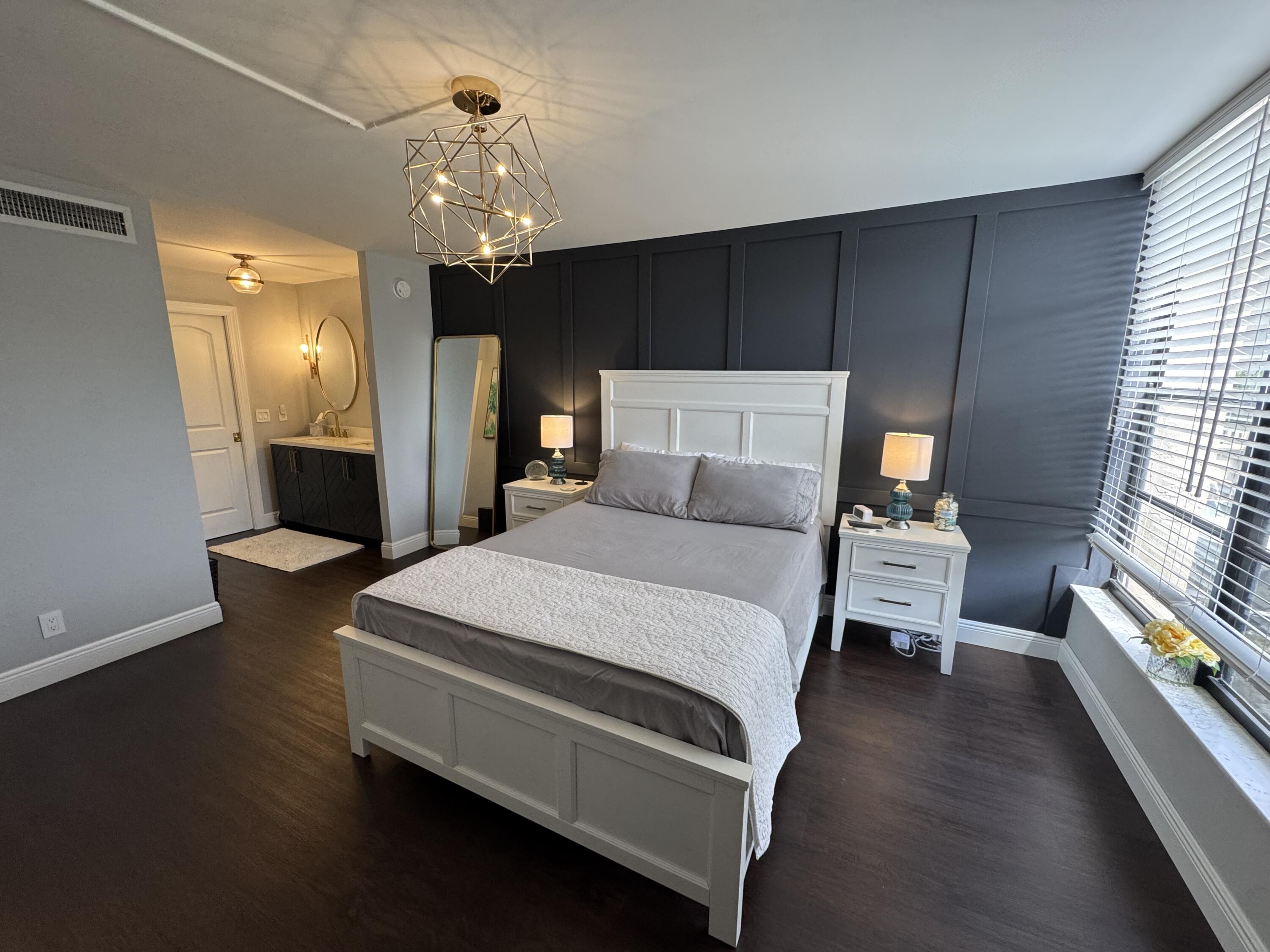 6 Royal Palm Way, Unit 202 Boca Raton, FL 33432 - Photo 6 of 29 a spacious bedroom with a bed and a chandelier