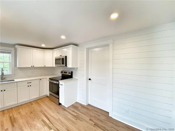 a large kitchen with cabinets and stainless steel appliances