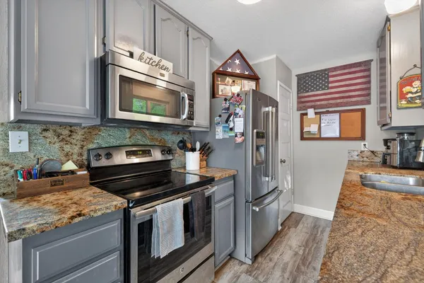 a kitchen with stainless steel appliances granite countertop a stove microwave and sink