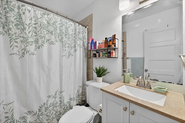 a bathroom with a sink a toilet and a shower curtain