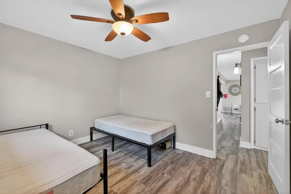 a view of a room with wooden floor and a chandelier fan