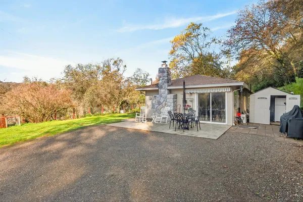 a view of a house with backyard and sitting area