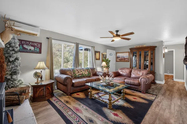 a living room with furniture ceiling fan and a window