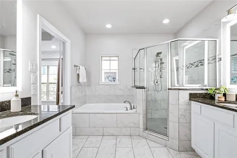 a spacious bathroom with a granite countertop tub sink shower and mirror