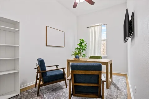 a view of a workspace with furniture and a window