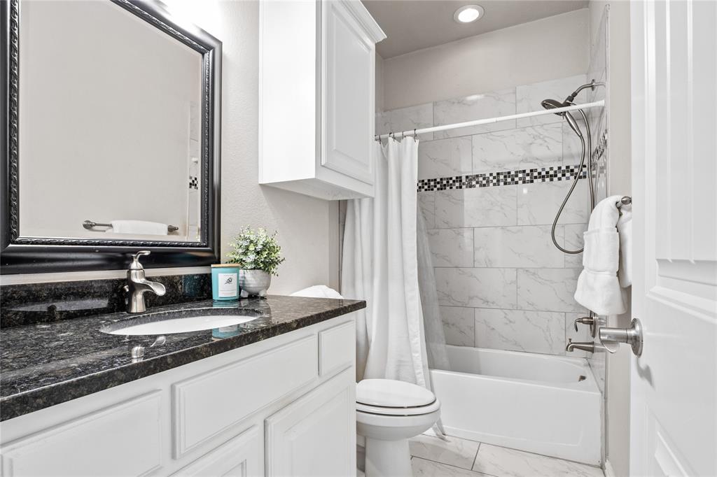 2205 Eriksson Lane Dallas, TX 75204 - Photo 15 of 18 a bathroom with a granite countertop sink a toilet and bathtub