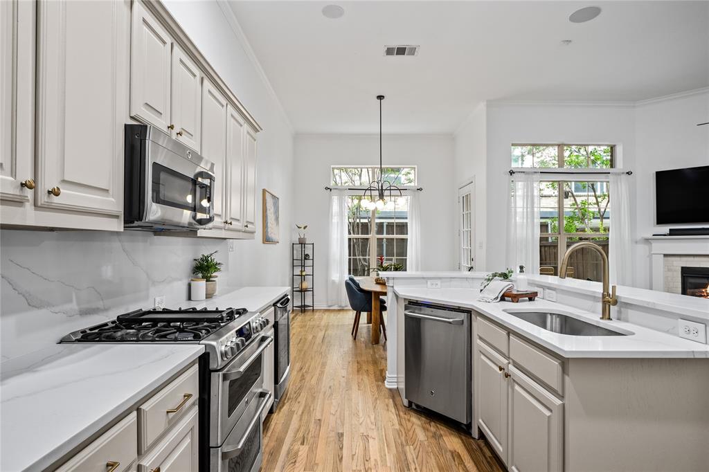 2205 Eriksson Lane Dallas, TX 75204 - Photo 6 of 18 a kitchen with stainless steel appliances a sink stove and wooden floor