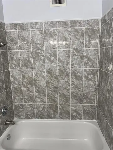 a bathroom with a bathtub and shower