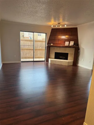an empty room with wooden floor fireplace and windows