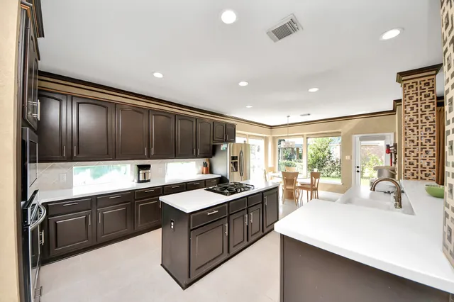 a kitchen with stainless steel appliances granite countertop a sink stove and cabinets