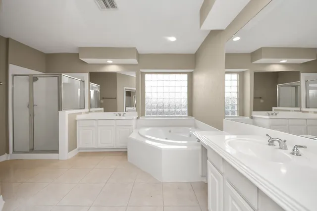 a bathroom with a tub a sink a mirror and a shower