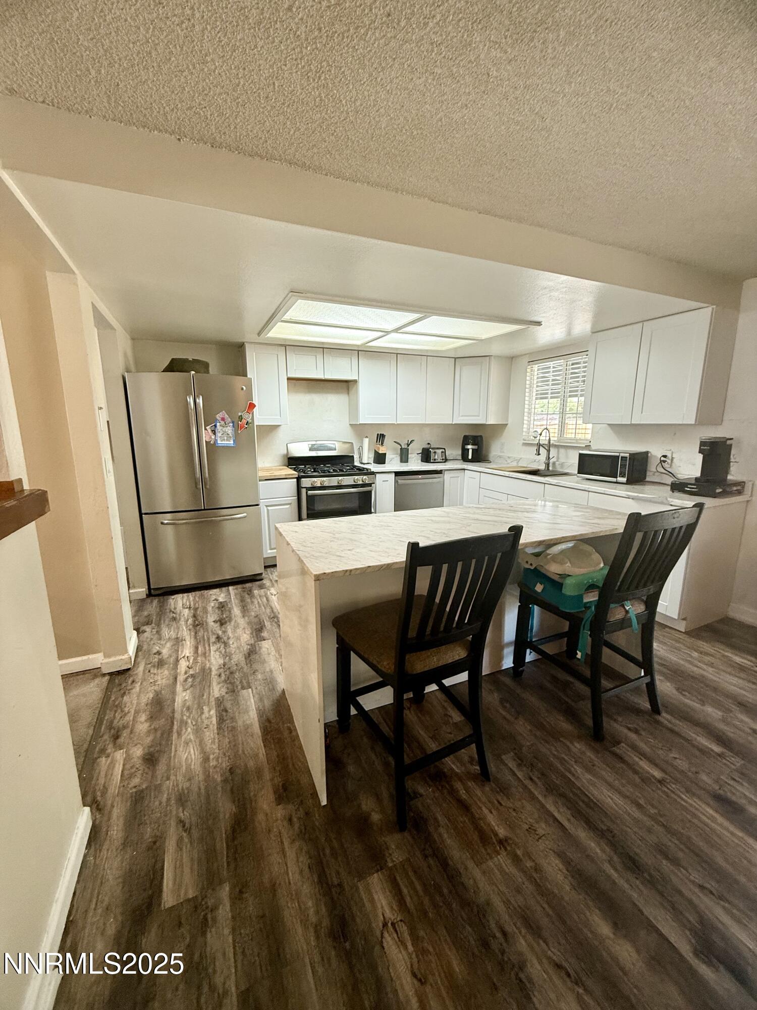 2775 Vicky Lane Minden, NV 89423 - Photo 4 of 6 a room with stainless steel appliances a dining table chairs and a refrigerator