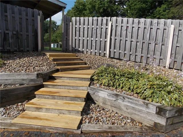 a view of stairs and yard with wooden fence