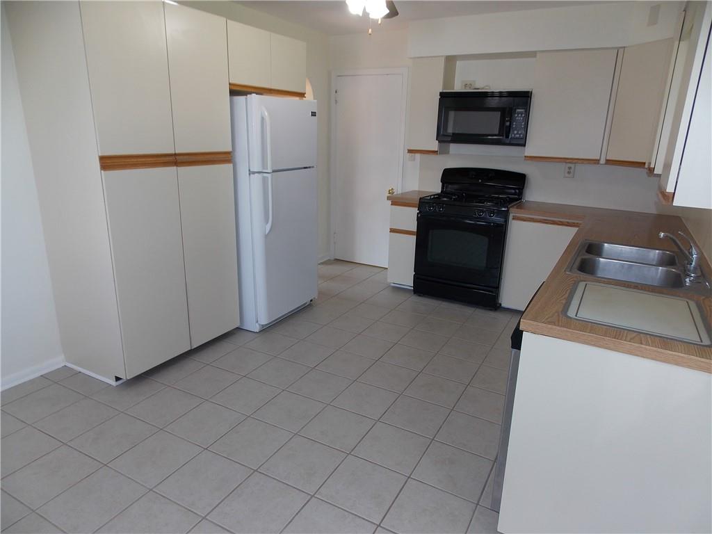 511 Pearl Avenue Mars, PA 16046 - Photo 4 of 20 a kitchen with a refrigerator and a stove top oven