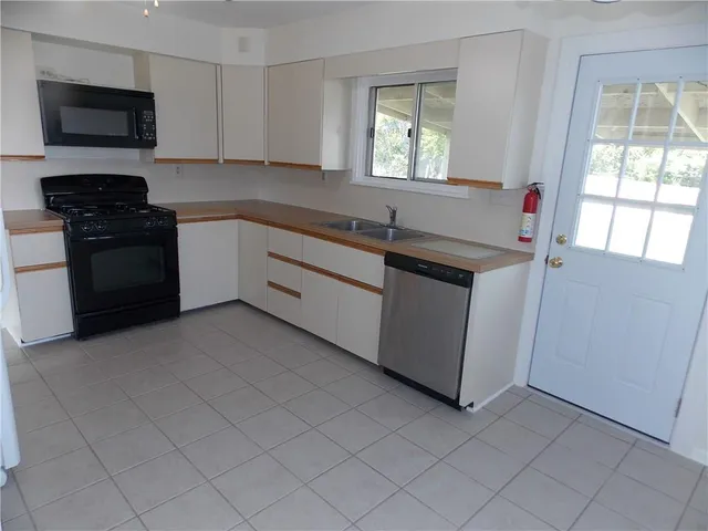 a kitchen with stainless steel appliances granite countertop a sink and a stove