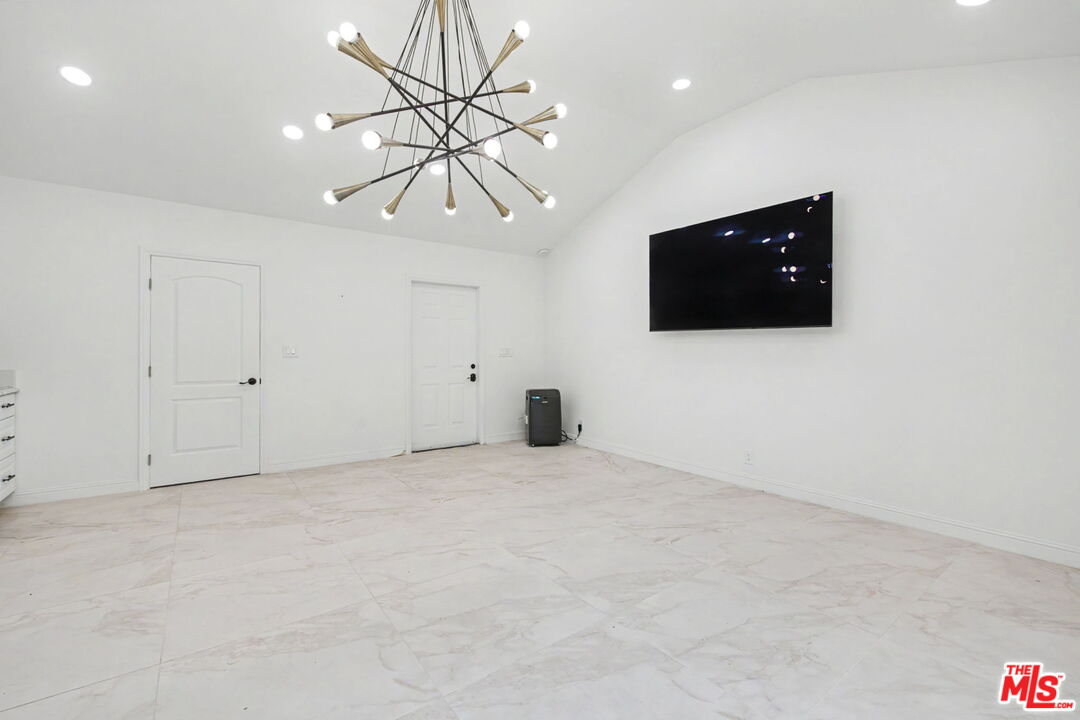 204 Foothill Road Beverly Hills, CA 90210 - Photo 38 of 38 a view of an empty room with a tv and a chandelier