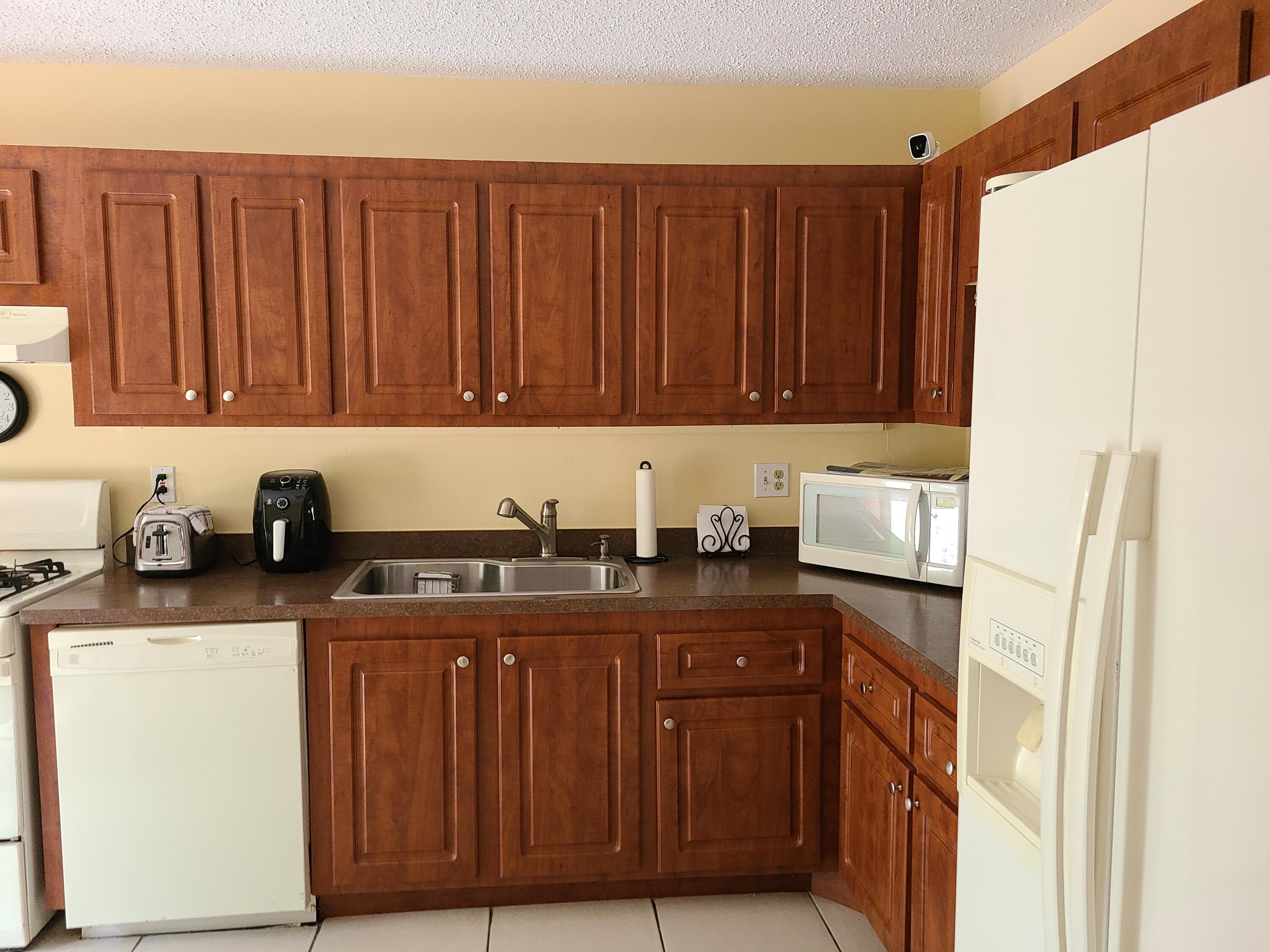5959 Triphammer Road Lake Worth, FL 33463 - Photo 8 of 10 a kitchen with stainless steel appliances granite countertop a refrigerator and a stove top oven