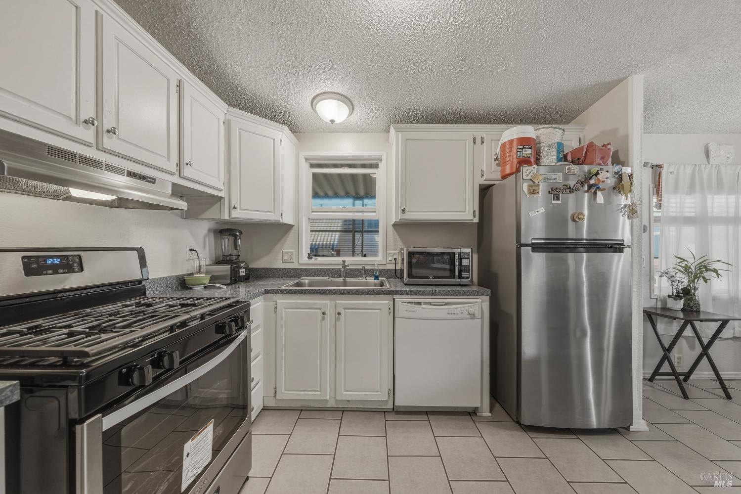 436 McCoy Avenue Santa Rosa, CA 95407 - Photo 10 of 27 a kitchen with stainless steel appliances granite countertop a stove top oven a refrigerator and cabinets