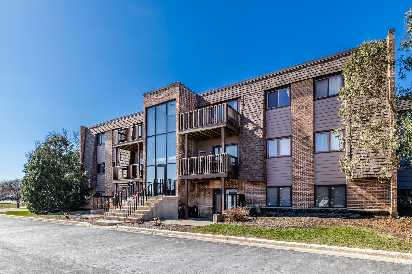 1440 Stonebridge Circle, Unit J7 Wheaton, IL 60189 - Photo 2 of 28 a view of a building with a street