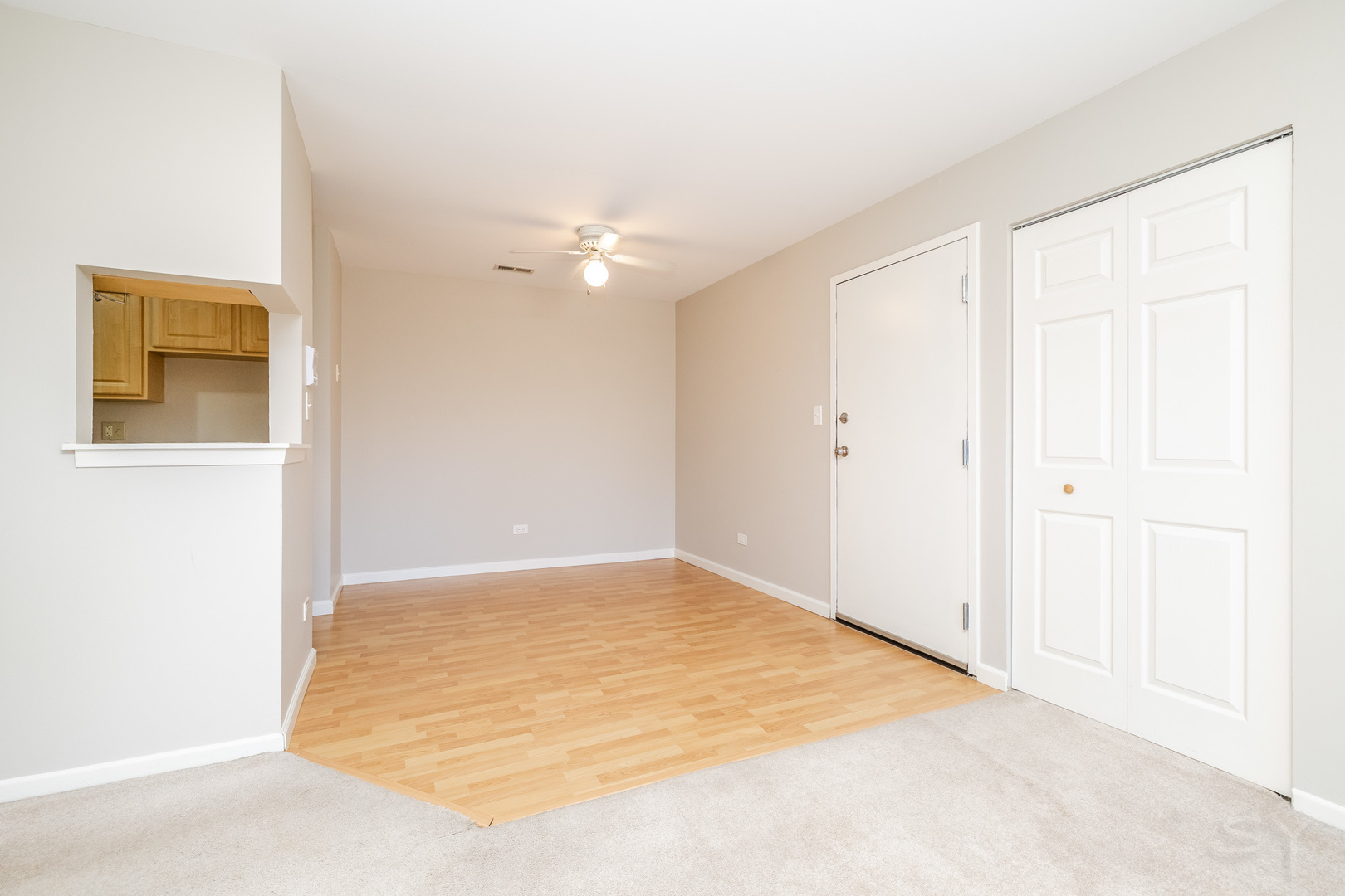 1440 Stonebridge Circle, Unit J7 Wheaton, IL 60189 - Photo 5 of 28 an empty room with a ceiling fan and a window
