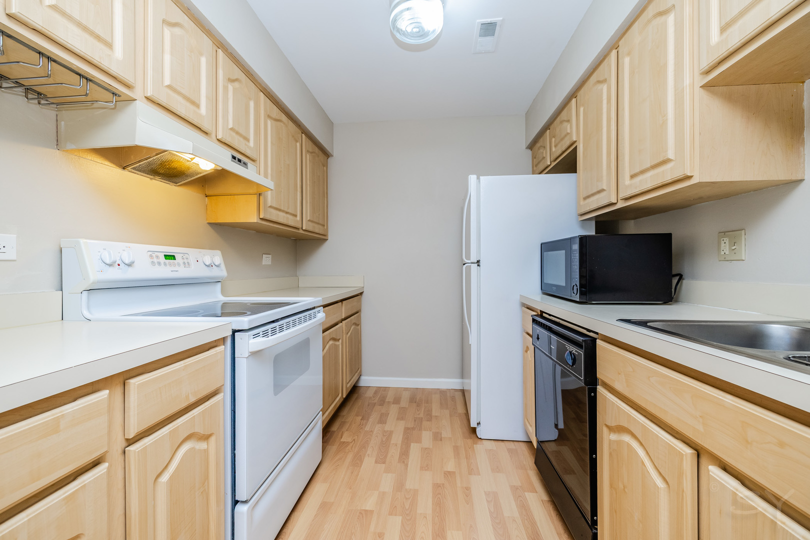 1440 Stonebridge Circle, Unit J7 Wheaton, IL 60189 - Photo 7 of 28 a kitchen with stainless steel appliances granite countertop a sink and a stove top oven