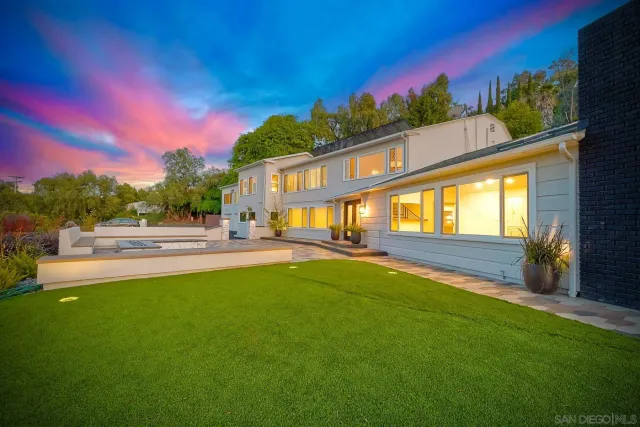 an aerial view of a house with swimming pool and a yard