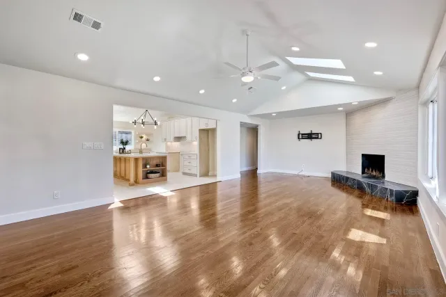 a view of empty room with wooden floor and windows