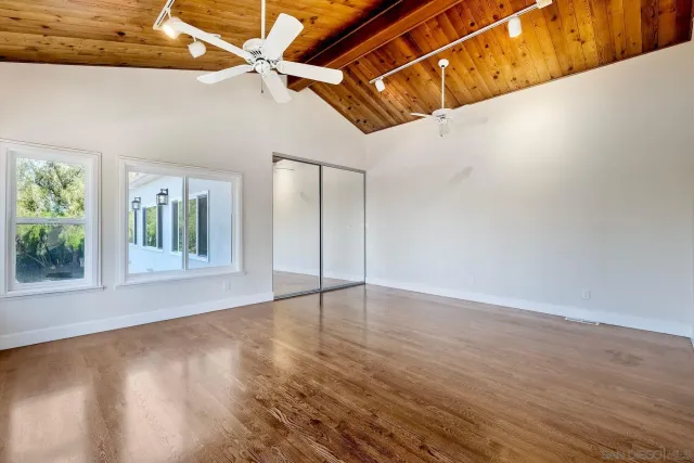 an empty room with fan and windows