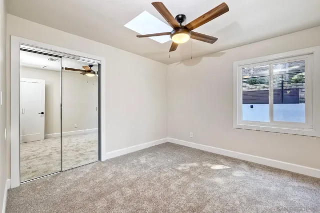 a view of a swimming pool with a bench and trees in the background