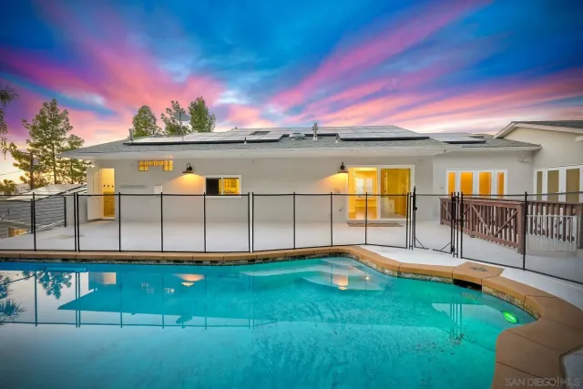 an aerial view of a house with swimming pool and big yard
