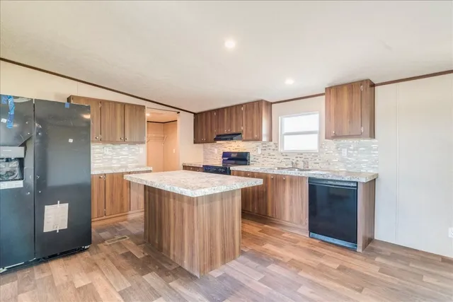 a kitchen with a sink a stove a refrigerator and cabinets