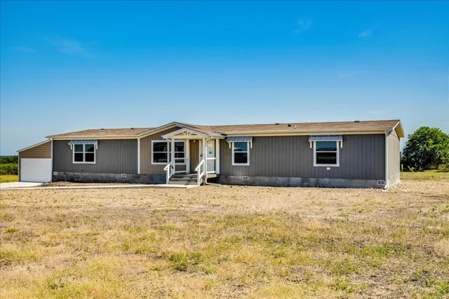 a front view of house with yard and garage