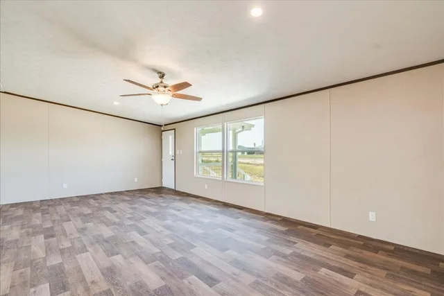 an empty room with window and ceiling fan