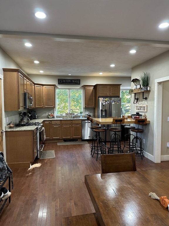 369 Chestnut Street Clinton, MA 01510 - Photo 4 of 21 a kitchen with stainless steel appliances kitchen island granite countertop a refrigerator a stove a sink a dining table and chairs with wooden floor