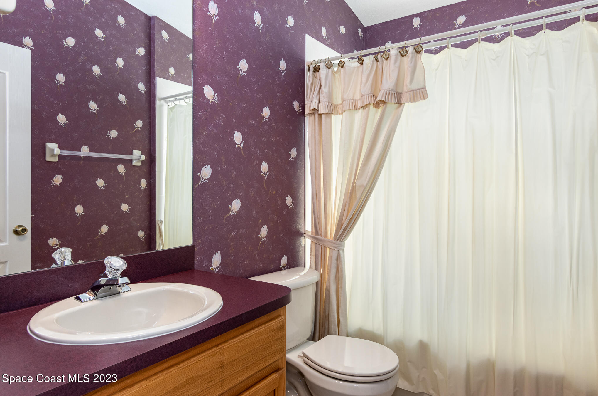 2140 Spring Creek Circle Palm Bay, FL 32905 - Photo 16 of 22 a bathroom with a sink vanity mirror and toilet