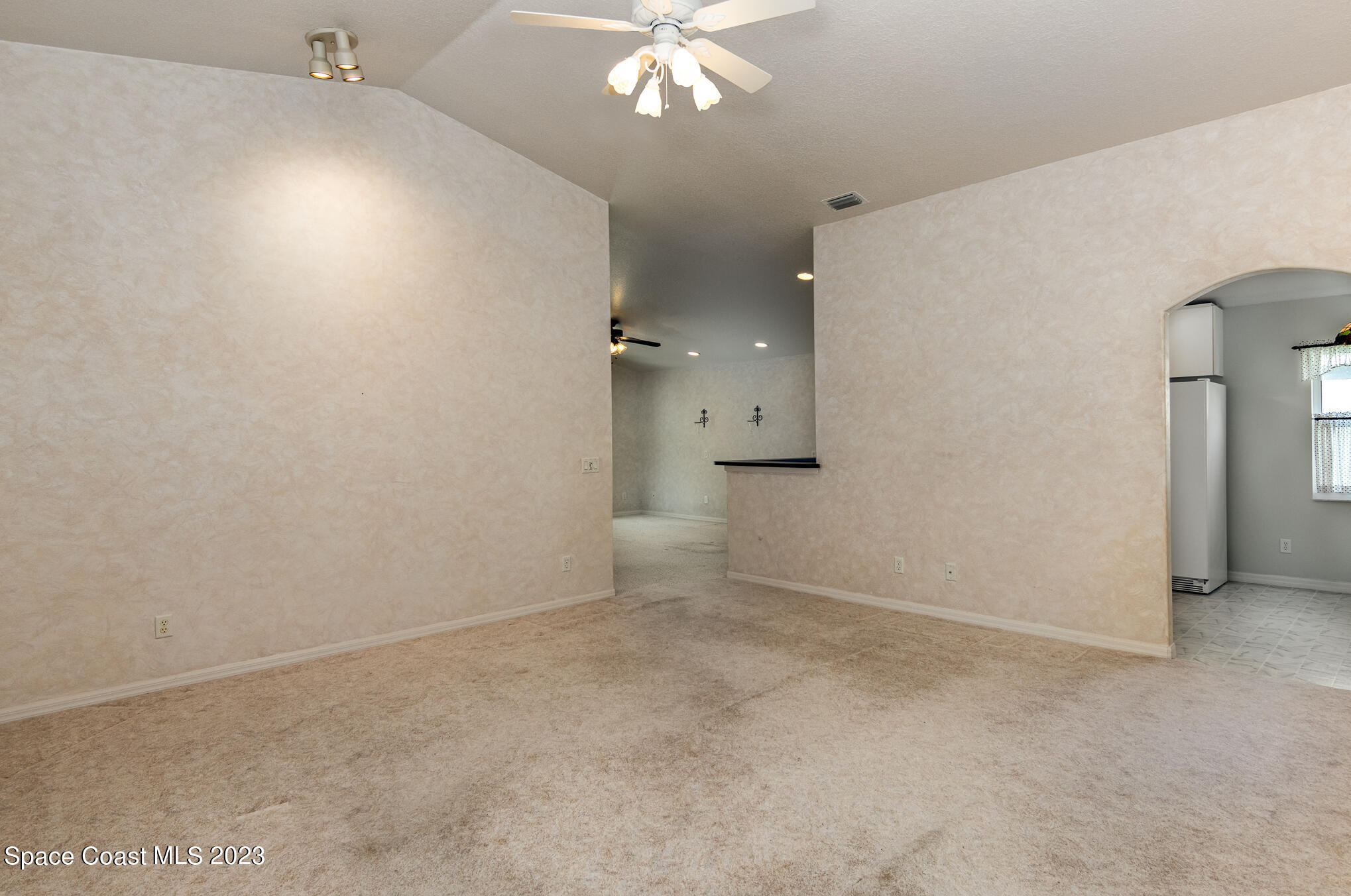2140 Spring Creek Circle Palm Bay, FL 32905 - Photo 3 of 22 an empty room with chandelier fan and windows