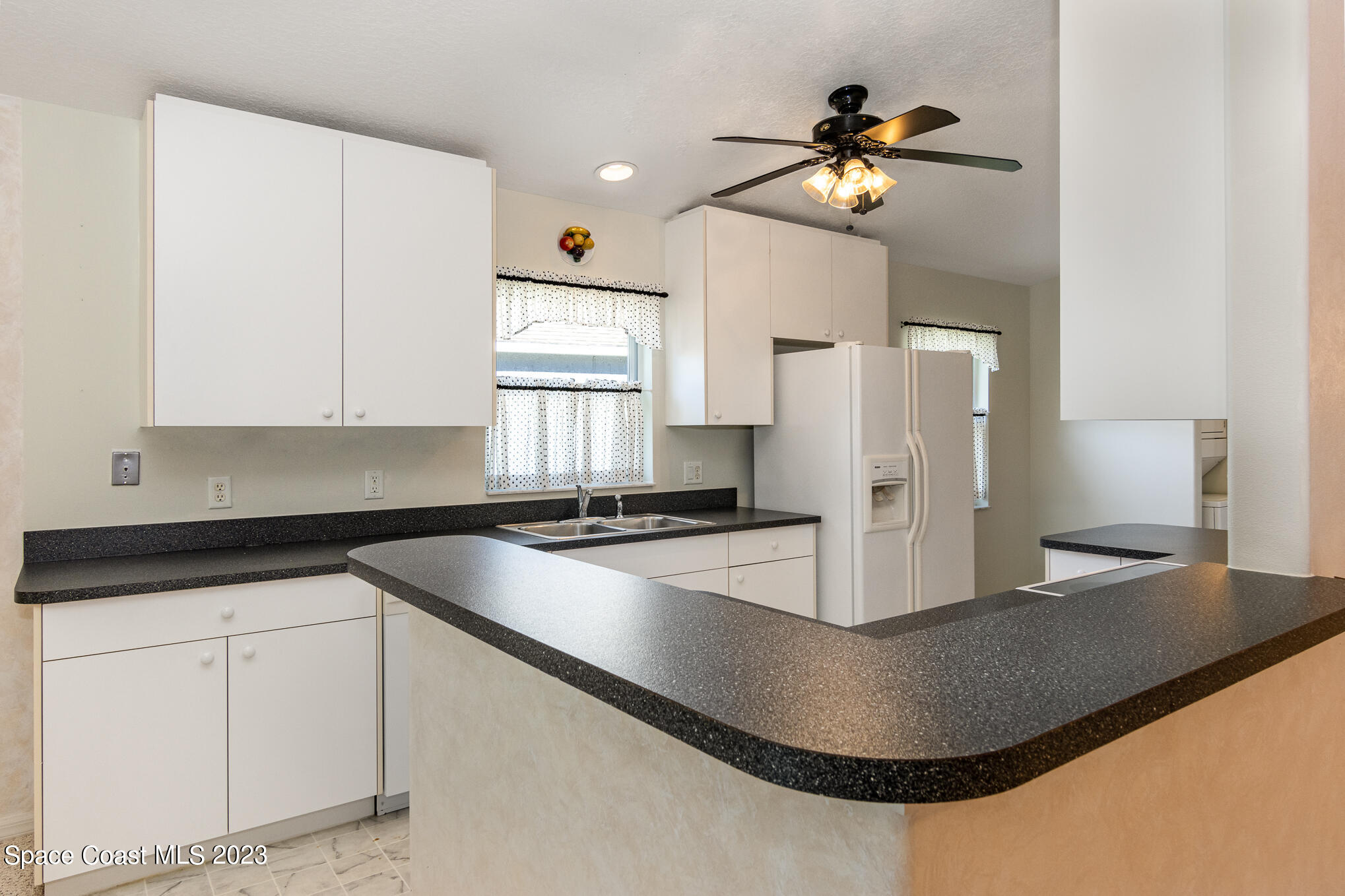 2140 Spring Creek Circle Palm Bay, FL 32905 - Photo 10 of 22 a kitchen with a sink a stove and refrigerator
