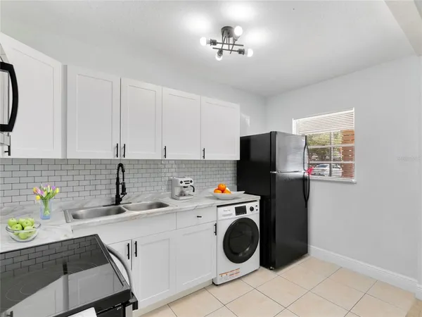 a view of a kitchen with a sink washer and dryer